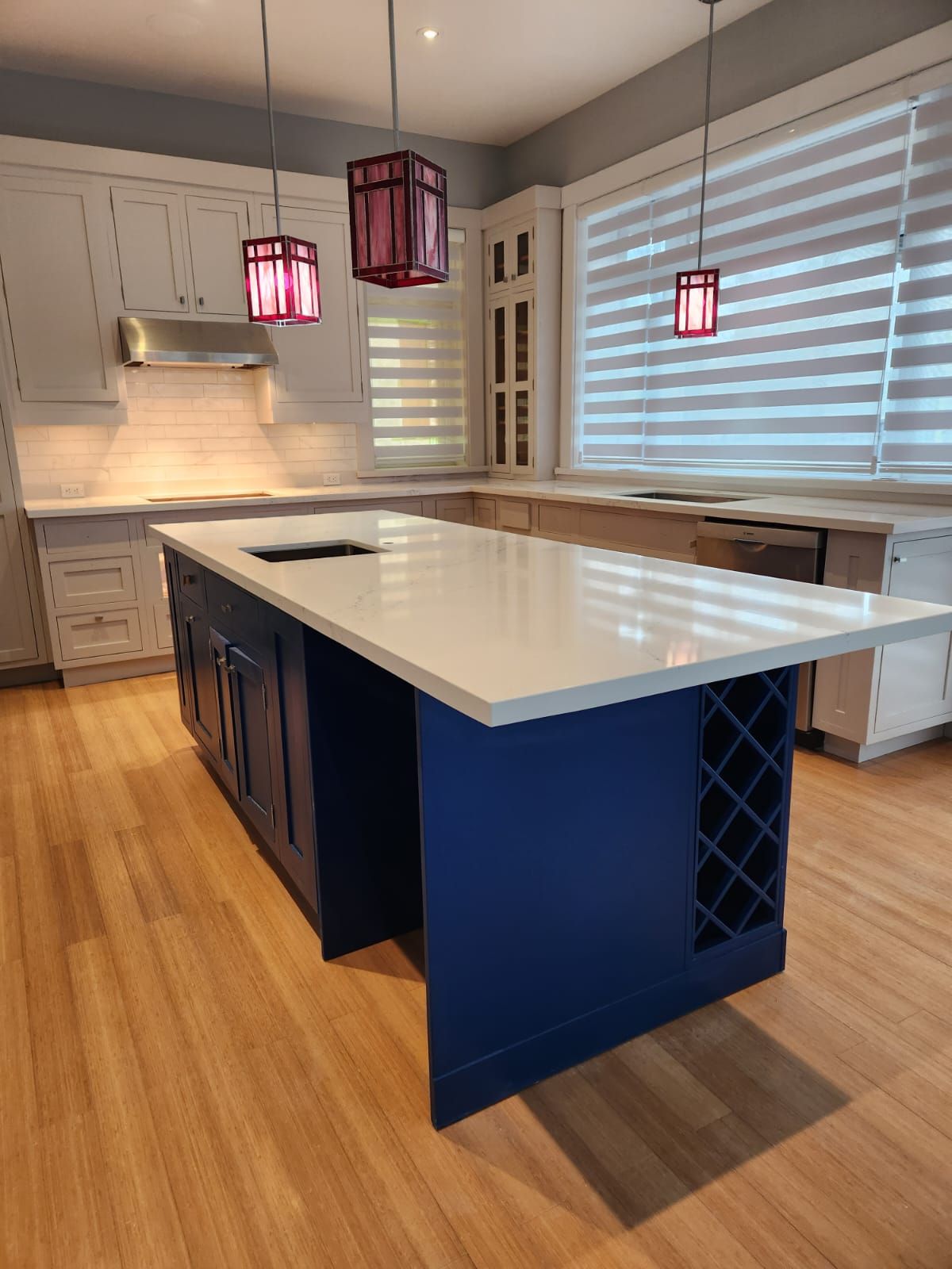 Kitchen island in deep blue with a quartz top and built-in wine storage