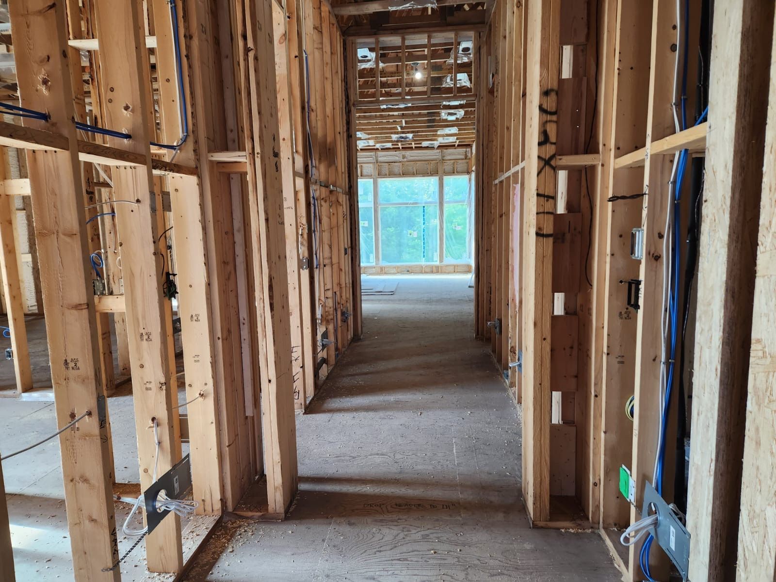 Framed hallway with rough wiring and plumbing before drywall