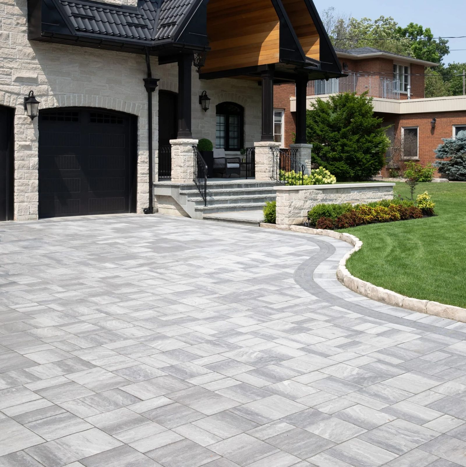 Paver driveway and stone entrance steps at the front of a home